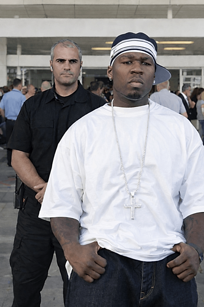 Kürşat Demir, ünlü hip-hop sanatçısı 50 Cent ile açık havada düzenlenen bir etkinlikte yan yana poz veriyor.